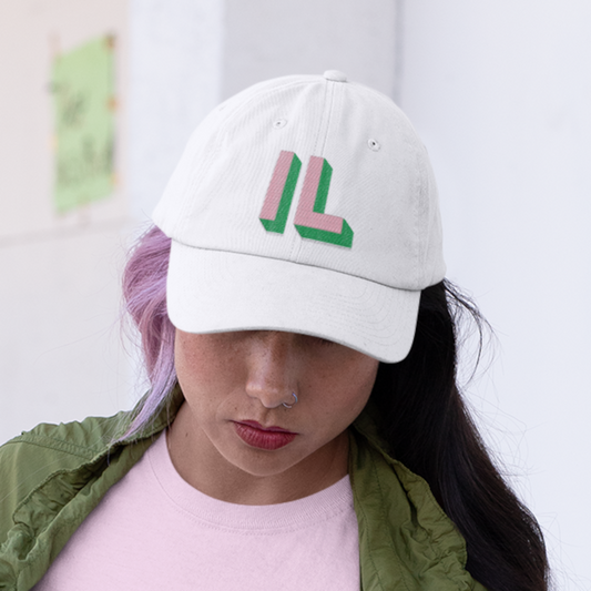 woman wearing white dad style cap with green and pink lettering